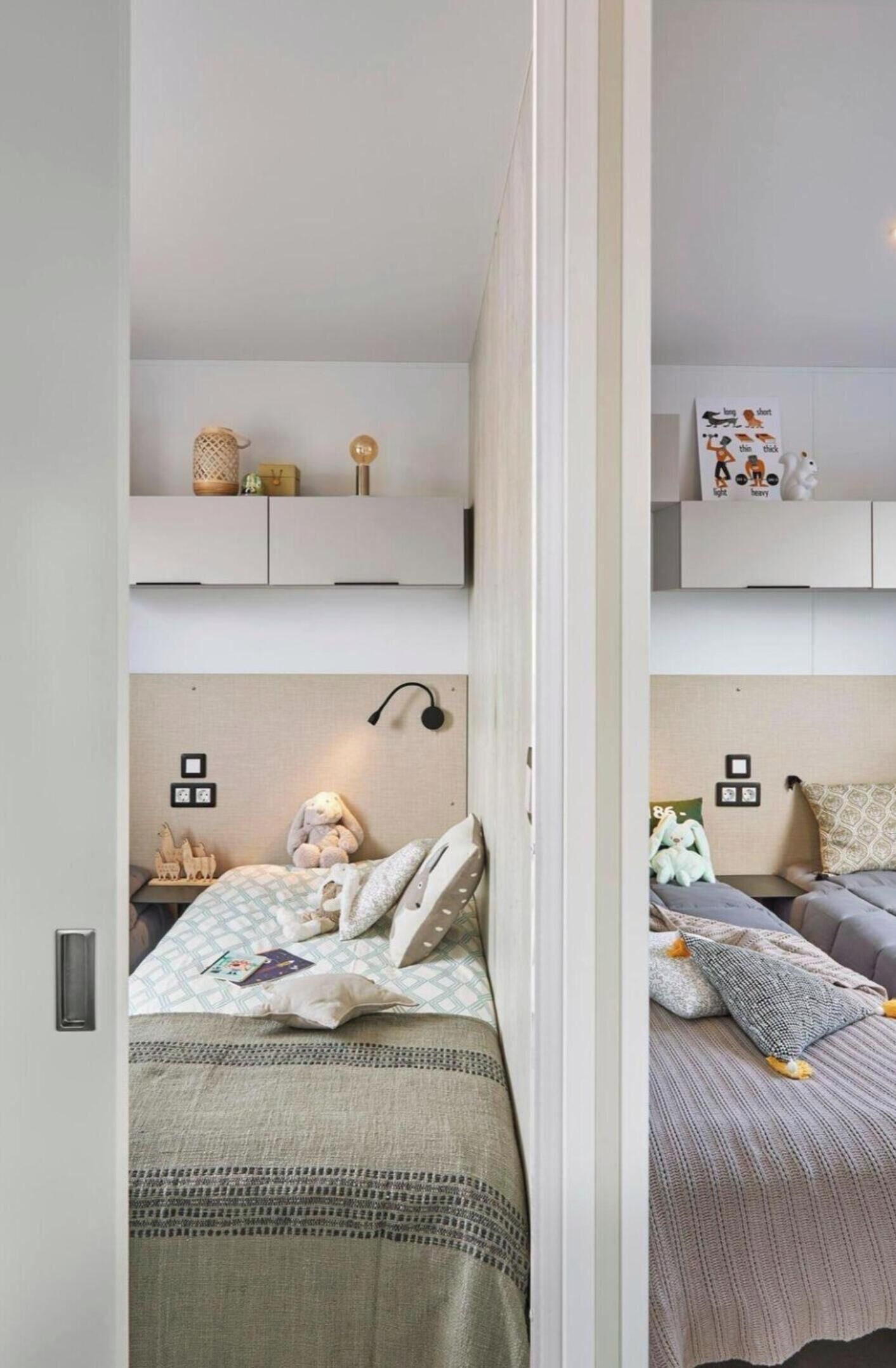 A bedroom with a bed, bedside table, lamp, and wall decorations.