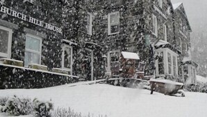 A snow-covered building with a sign reading 'Church Hill House.' - Church hill house (Betws-Y-Coed)