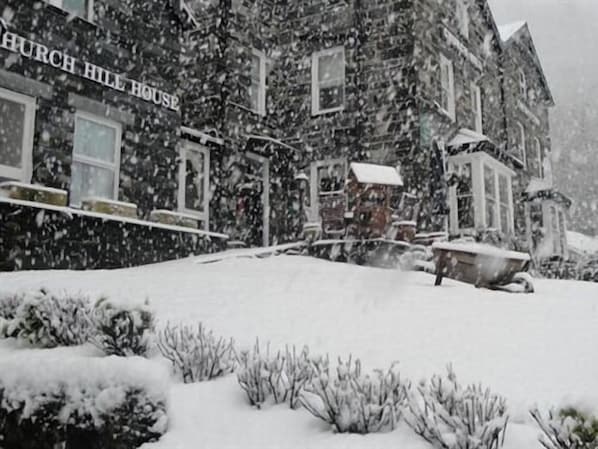 A snow-covered building with a sign reading 'Church Hill House.'