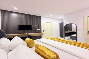 A modern hotel room with a bed, a TV, a mirror, and a door. - UV Residence | 2BR Duplex (Lekki)