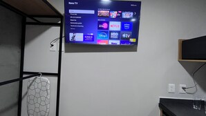 Ein Flachbildfernseher an der Wand, der eine Streaming-Dienstoberfläche mit verschiedenen App-Symbolen anzeigt.