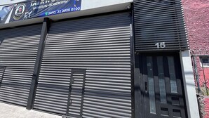 Ein Gebäude mit heruntergelassener Rolltür, einem Schild für 'Taekwondo Yongun Academy' und der Nummer '15' an der Tür.