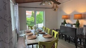 Ein Essbereich mit einem langen Tisch, gelben Stühlen und einem Deckenventilator.
