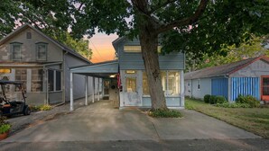 Ein zweigeschossiges Haus mit verdeckter Veranda, Garage und Auffahrt.