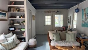 Ein gemütliches Wohnzimmer mit einer Couch, einem Couchtisch und einem Bücherregal.