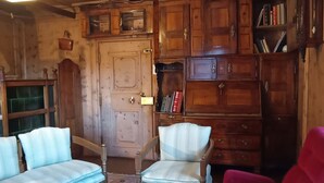 Un intérieur en bois avec une porte, des étagères intégrées et deux fauteuils rembourrés.