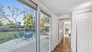 A modern interior with a wooden deck, sliding glass doors, and a view of the backyard. - Cozy 3BR Clearwater Home w/ Private Pool & Backyard Oasis (Clearwater)