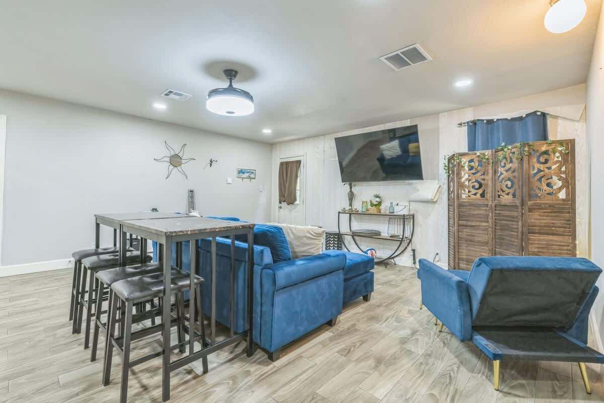 A living room with a sofa, chairs, a TV, and a dining table.