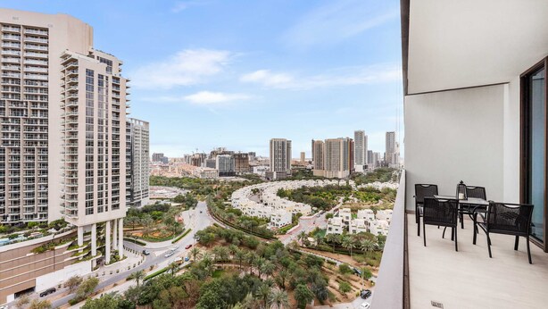 A high-rise building with a balcony featuring outdoor furniture. - Free Housekeeping Visits During Your Stay - Stayshort - Elegant 1 Bedroom in JVC Sleeps 4 With Balcony (Dubai)