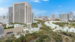 A high-rise building with multiple floors, surrounded by greenery and other buildings. - Free Housekeeping Visits During Your Stay - Stayshort - Elegant 1 Bedroom in JVC Sleeps 4 With Balcony (Dubai)