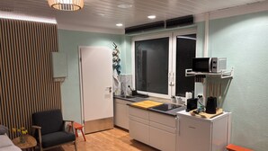 A compact kitchen with a microwave, sink, and wooden cabinets. - Studio with kitchen in the center of Auerbach near Fürstenlager (Bensheim)