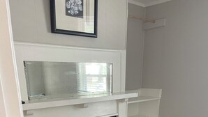 A room with a white fireplace, a framed picture above it, and a wooden floor. - Stylish 3BR Apt in Savannah’s  Perfect for  Nurses, students  & Professionals! (Savannah)