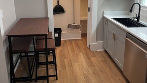 A kitchen with a wooden table and chairs, a dishwasher, and a window. - Stylish 3BR Apt in Savannah’s  Perfect for  Nurses, students  & Professionals! (Savannah)