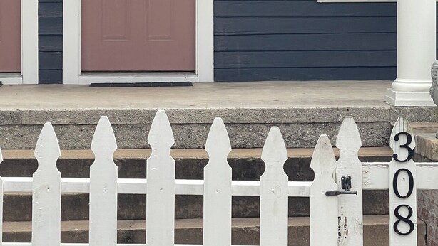 A house with a dark blue exterior, a pink door labeled '308A', and a white picket fence with the number '308' on the post. - Stylish 3BR Apt in Savannah’s  Perfect for  Nurses, students  & Professionals! (Savannah)