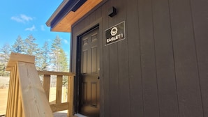 A wooden deck leading to a dark-colored building with a sign reading 'EAGLET 1'.