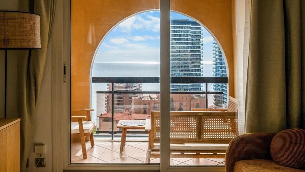 Un balcone con vista su edifici e un cielo sereno.