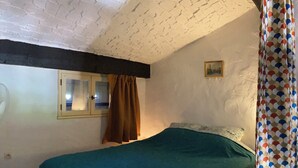 A bedroom with a bed, a window with curtains, a picture on the wall, and a patterned curtain. - Mazet garden level sea view close to calanques and beach (Saint-Raphaël)