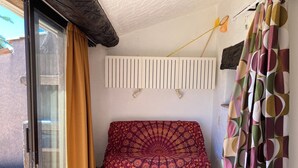 A room with a bed, a curtain, a wall-mounted light fixture, and a window. - Mazet garden level sea view close to calanques and beach (Saint-Raphaël)
