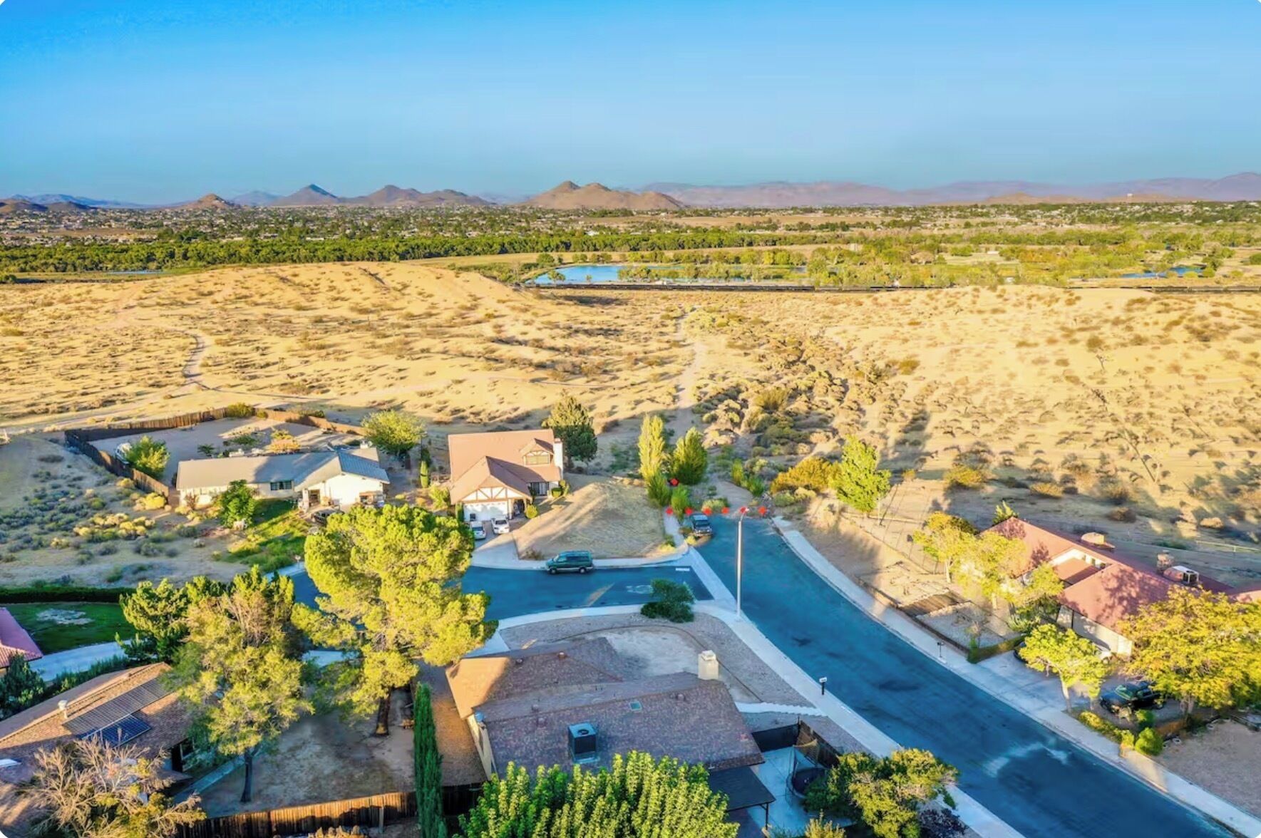A residential area with houses, a road, and a distant mountain range.