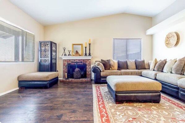 A living room with a fireplace, a sofa, a loveseat, and a rug.