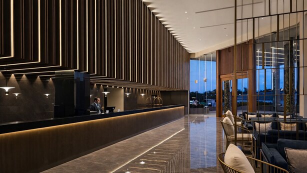 A modern hotel lobby with a reception desk, seating area, and large windows. - colombo international airport hotel (Katunayake)