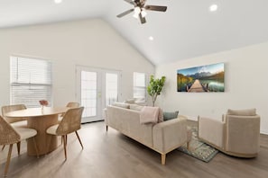 A spacious living area with a dining table, sofa, and a ceiling fan. - The Royal Inn (Lafayette)
