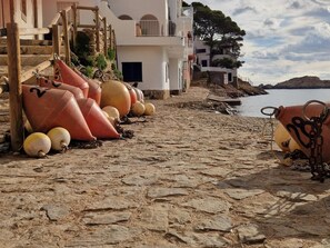 A cobblestone path leading to a coastal building with a stone staircase and a view of the sea. - Casa Santani (Begur, Sa Tuna) (Sa Tuna, Begur)