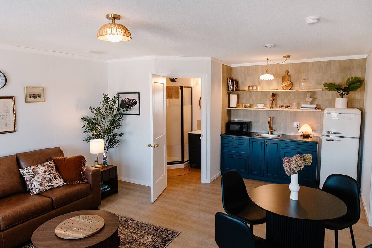 Un espacio habitable compacto con kitchenette, comedor y sala de estar.