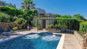 A swimming pool with a stone border, surrounded by lounge chairs and a pergola. - Los Rosales del Jaral El Gastor by Ruralidays (Cádiz)