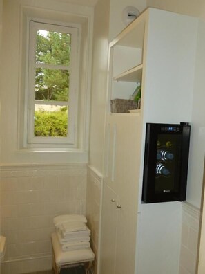 A bathroom with a window, a towel rack, and a water dispenser.