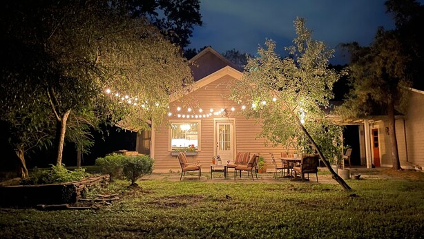 A house with a porch, outdoor seating, and string lights. - Hudson Pond · Garden Queen Suite · GF Breakfast (Poughkeepsie)