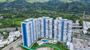 A high-rise residential building with multiple floors, surrounded by lush green hills. - MonteAzul apto con vista a la Cordillera (Armenia)