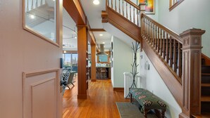 A spacious interior with a wooden staircase, a dining area, and a kitchen with a large window. - Tatalias House ~ Near Space Needle~Sports Arena~Sea Center~AC~Parking~PetsOK~NFL (Seattle)
