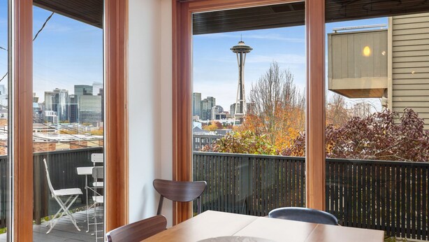 A balcony with a view of the Seattle skyline, including the Space Needle, and a table with chairs. - Tatalias House ~ Near Space Needle~Sports Arena~Sea Center~AC~Parking~PetsOK~NFL (Seattle)