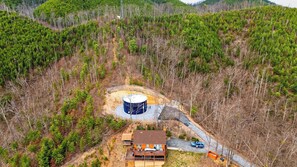 A house with a large water tank, surrounded by a forested area. - The Hangout Cabin by Avantstay Hot Tub + Game Room + Firepit + Near Gatlinburg + Dollywood (Gatlinburg)