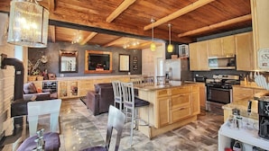 A spacious kitchen with wooden cabinets, a central island, and modern appliances. - The Old Maine Barn - Near Acadia & Bar Harbor (Ellsworth)