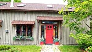 A wooden house with a red door, a welcome sign, and a number '14' on the wall. - The Old Maine Barn - Near Acadia & Bar Harbor (Ellsworth)