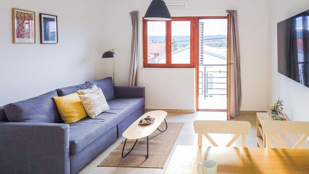 En stue med sofa, sofabord, spisebord og fjernsyn.