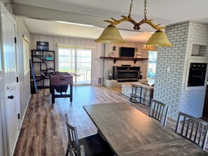 A spacious kitchen with a dining area, a fireplace, and a television.