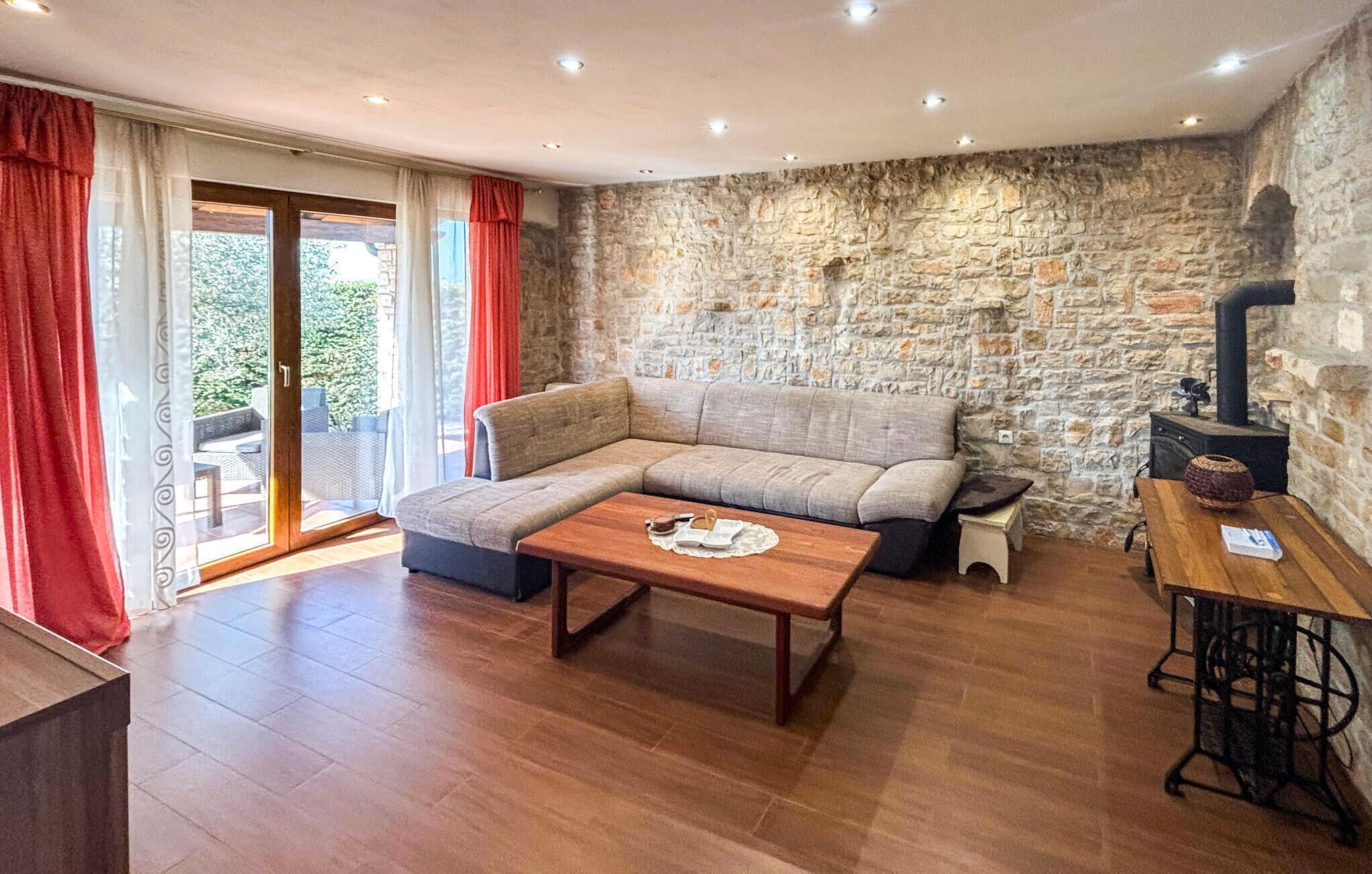 Ein gemütliches Wohnzimmer mit einer Steinwand, einem Sofa, einem Couchtisch und einem Kamin.