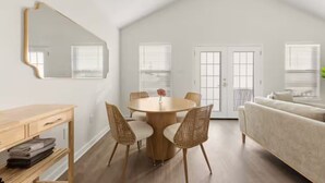 Un loft moderne comprenant un coin repas, un canapé et un grand miroir.