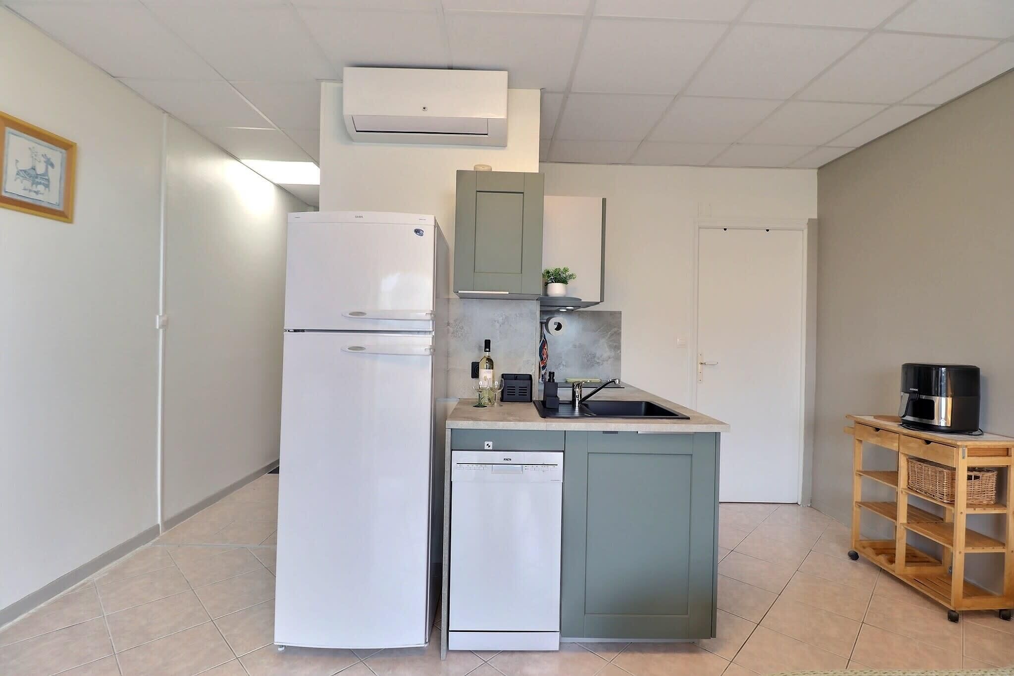 A compact kitchen with a refrigerator, dishwasher, and a small sink area.