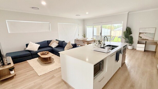 Un espacio moderno para vivir con una isla de cocina, un sofá y una zona de comedor.