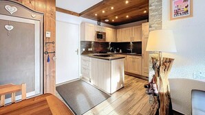 Une cuisine avec des meubles en bois, un îlot central et une suspension.