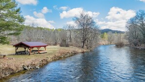 A riverside pavilion with a red roof, surrounded by trees and a clear sky. - Soothing studio apartment - on the Battenkill River in charming, Shushan (Shushan)