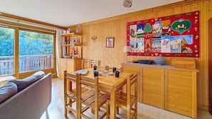 Un interior acogedor de madera con comedor, sofá y un amplio ventanal.