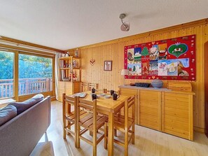 Ein gemütliches Holzinterieur mit Essbereich, einer Couch und einem großen Fenster.
