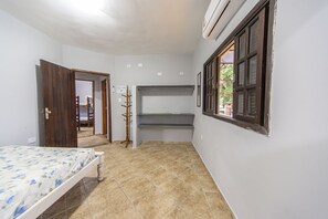 Ein Schlafzimmer mit Bett, Fenster, Tür und einer Treppe.