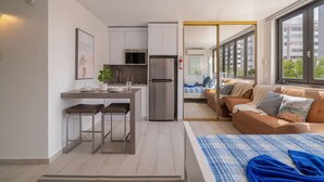 Un espai habitable compacte amb cuineta, sofà, llit i vistes a l'exterior.