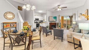 Una sala de estar moderna con una mesa de comedor, sillas, un sofá y un televisor.